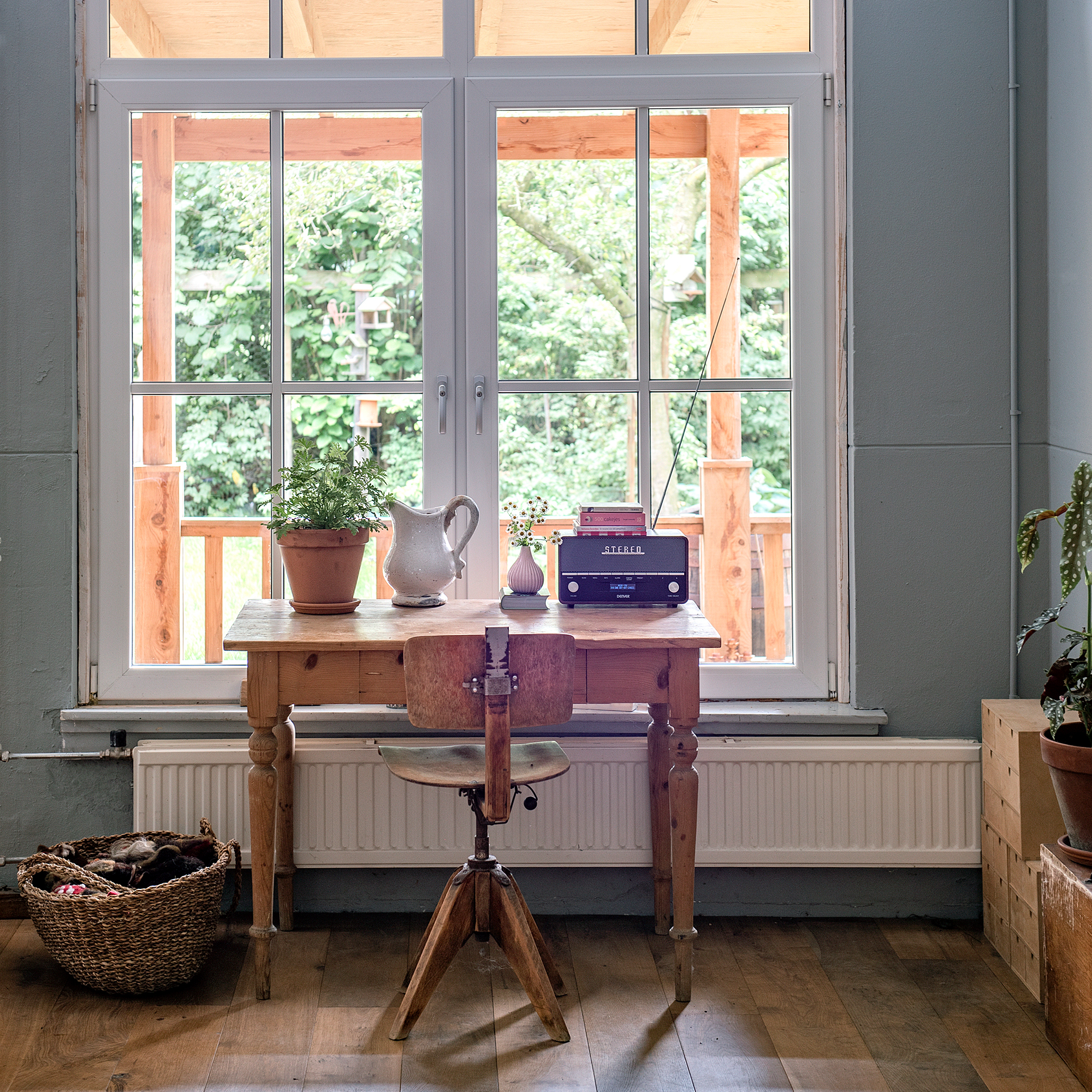 vintage desk and chair in front of a large window looking out on a verandah