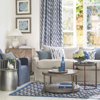 blue living room with light grey sofa and blue rug and blue curtains