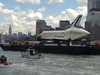 NASA's space shuttle Enterprise sails up New York City's Hudson River with the Empire State Building in the background while en route to its new home, the Intrepid Sea, Air and Space Museum on June 6, 2012.