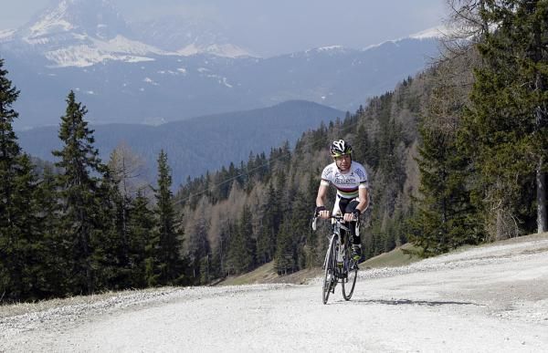 Cadel Evans clears the trees and heads up to the barren slopes above.