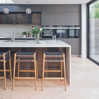 Modern grey kitchen with kitchen island and stools.