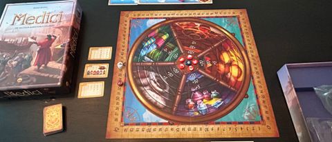 Medici board game box and board on a dark surface
