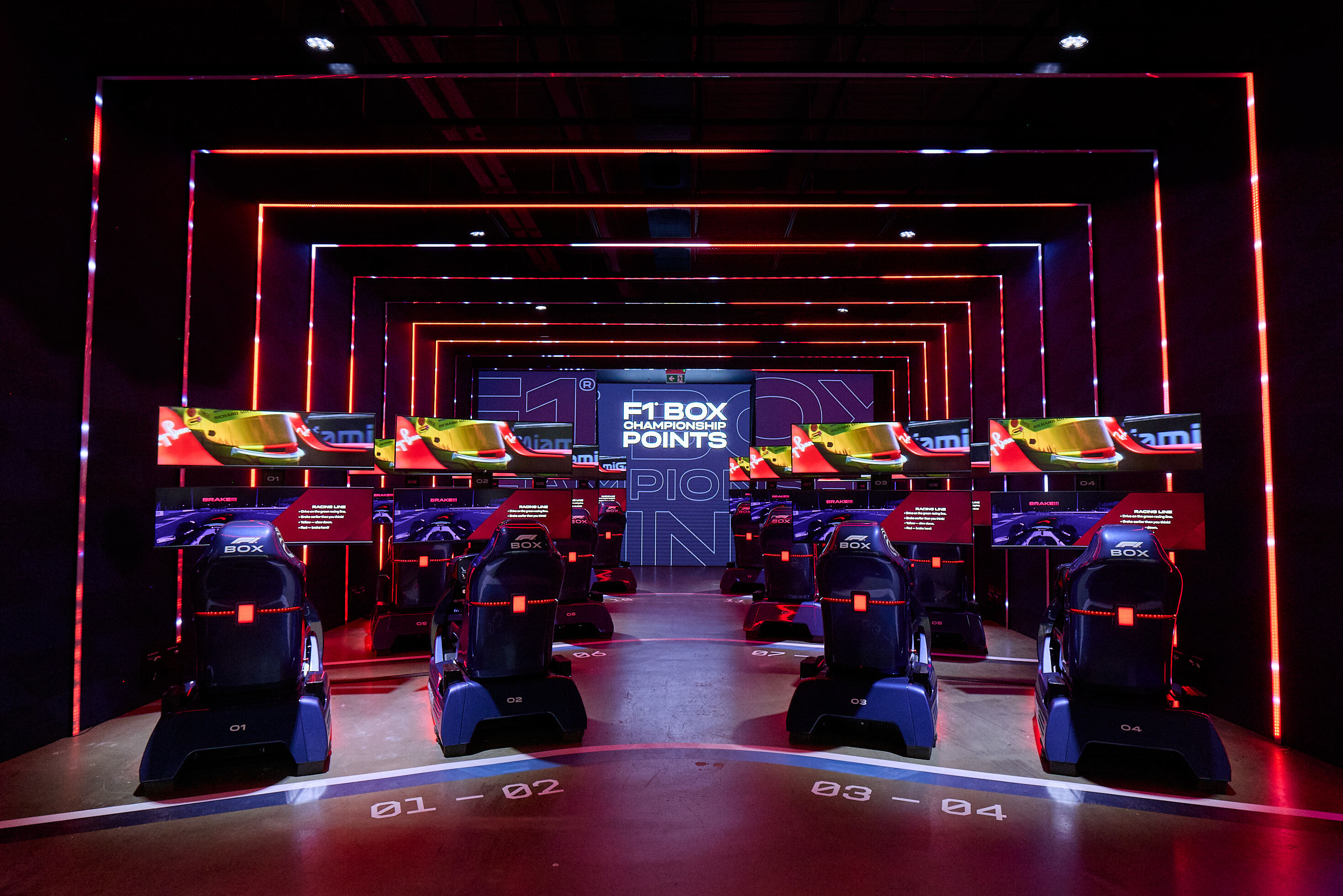 The interior of the F1 Box F1 racing simulator alit in blue and red lights.