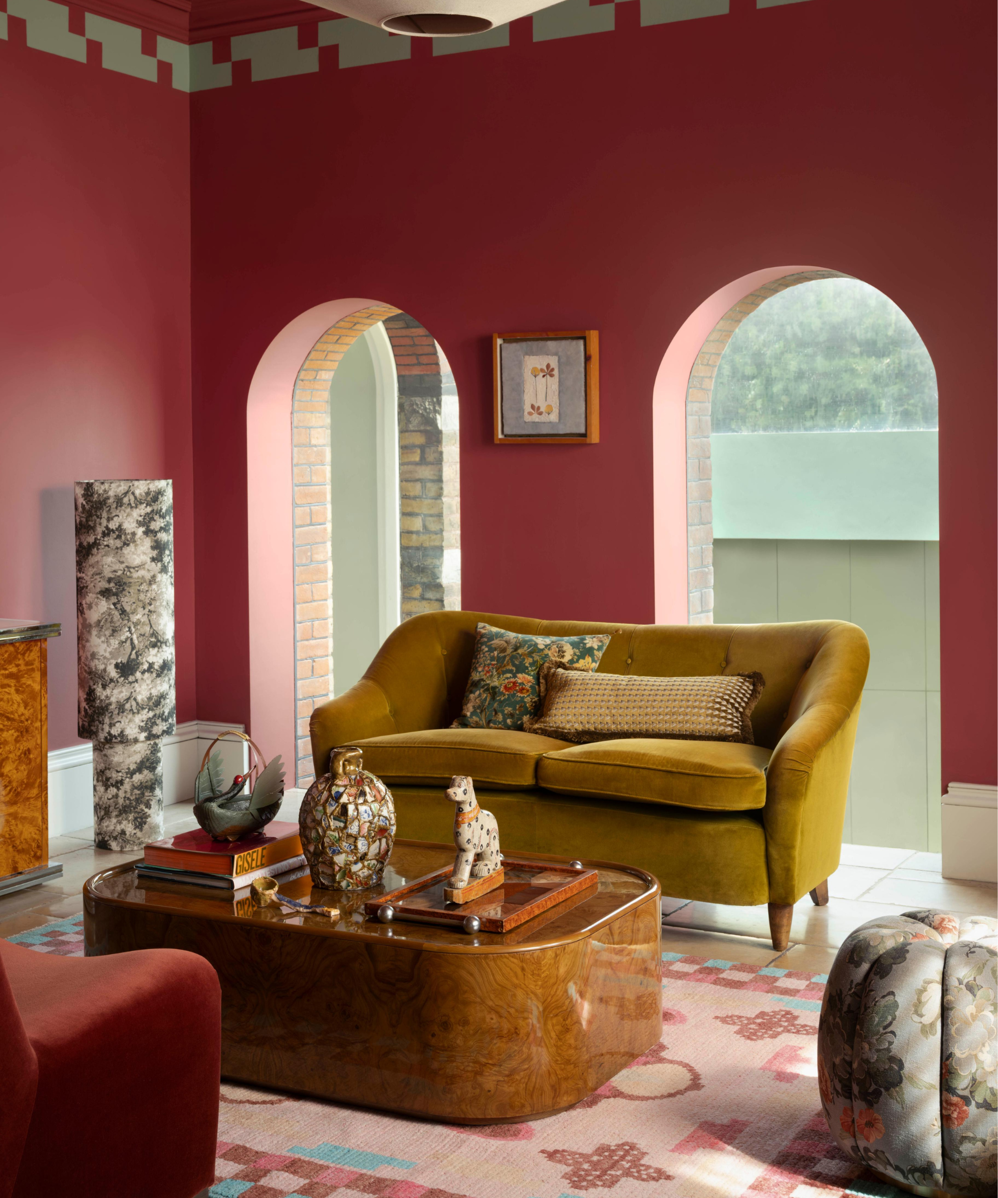 Living room with red pink walls and rug beneath sofa and coffee table in the middle of the room