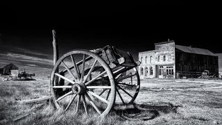 Black and white pic of old cart in front of wild west town