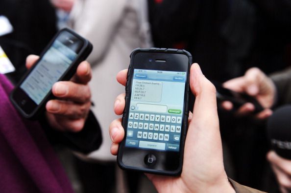 Two people text on their phones.