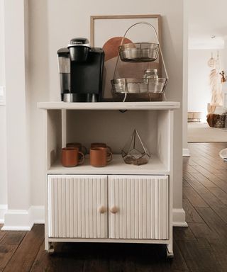 A DIY coffee bar in a hallway with upcycled white cabinet and coffee accessories