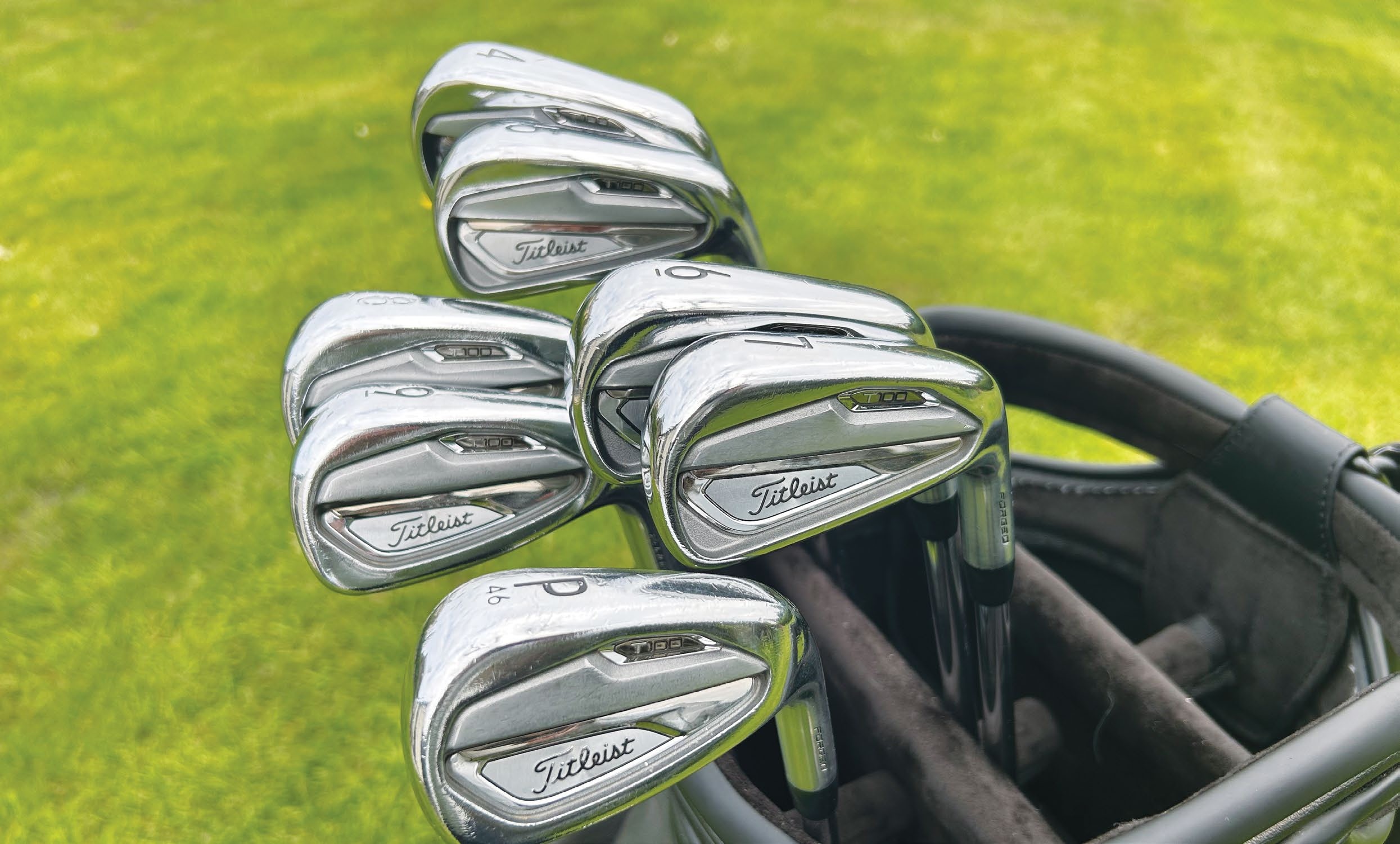 A close-up view of a set of Titleist golf irons resting in a golf bag, featured in an article about a six-year-old iron set that earned a tour player $4 million.