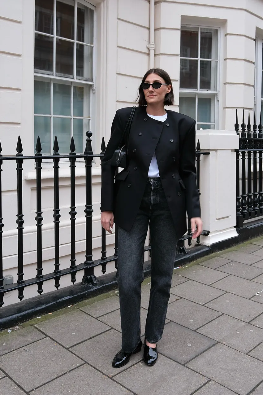 A woman wears skinny jeans with a boxy black blazer