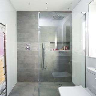 bathroom with white and grey tile wall and shower cabin