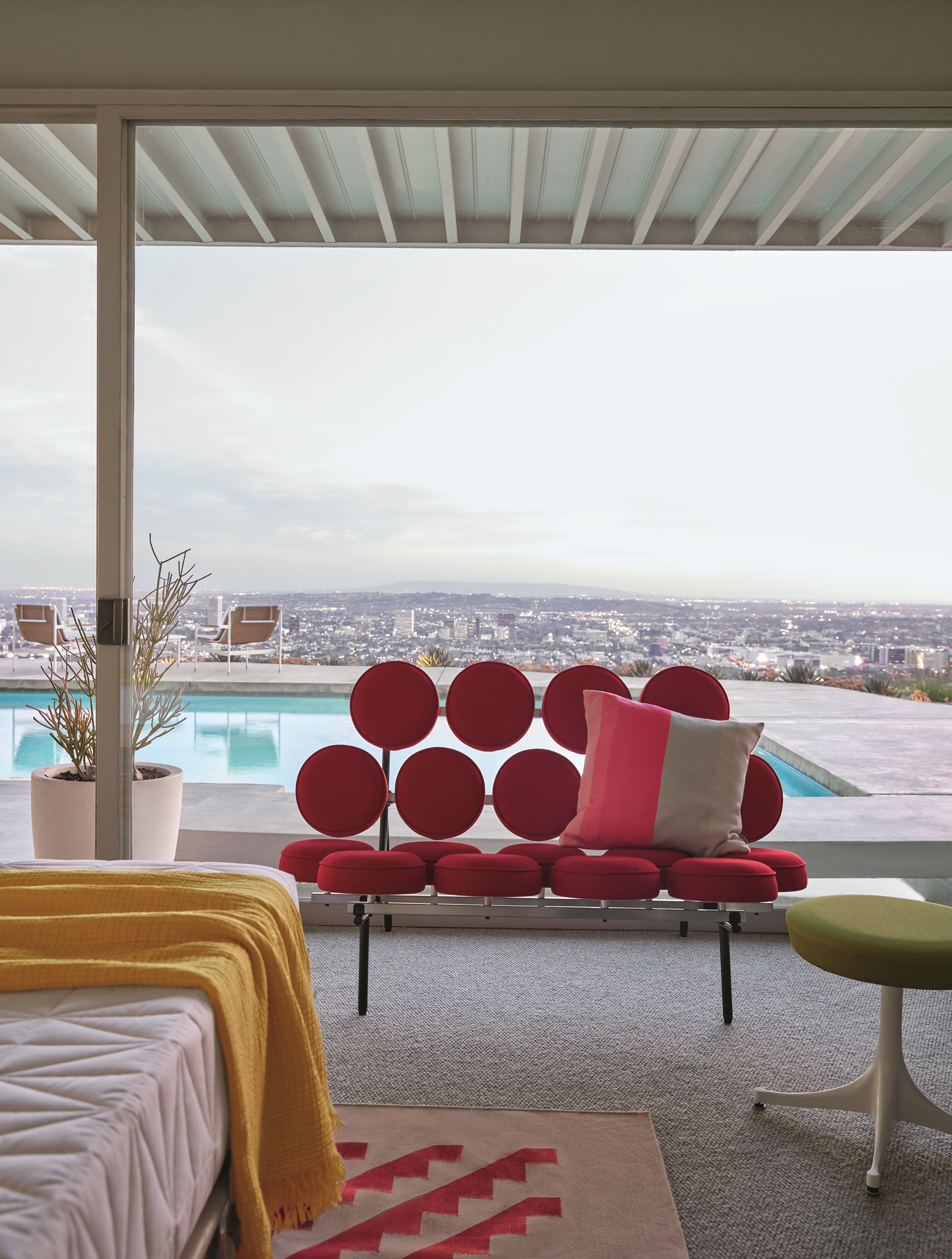 herman miller's marshmallow sofa in a bedroom overlooking a pool and skyline