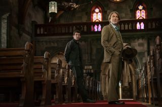 A shaggy looking Daniel Craig stands in a church along with Josh O'Connor, in Wake Up Dead Man: a Knives Out mystery.