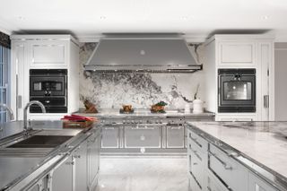 Kitchen with double island and marble backsplash