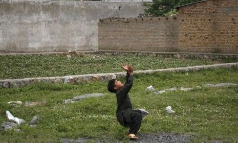 A boy plays with a ball in front of Osama bin Laden&amp;#039;s Pakistan compound: Neighborhood kids would not get their balls returned if they were lost in the terrorist&amp;#039;s yard.