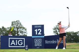 Ally Ewing hits a tee shot in front of an AIG Women's board