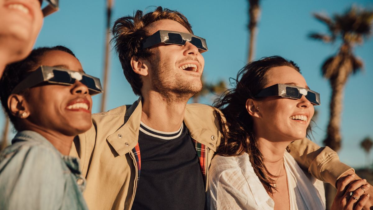 group of friends using solar eclipse glasses