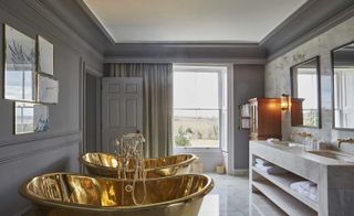 Grey bathroom with marble floor and two copper baths