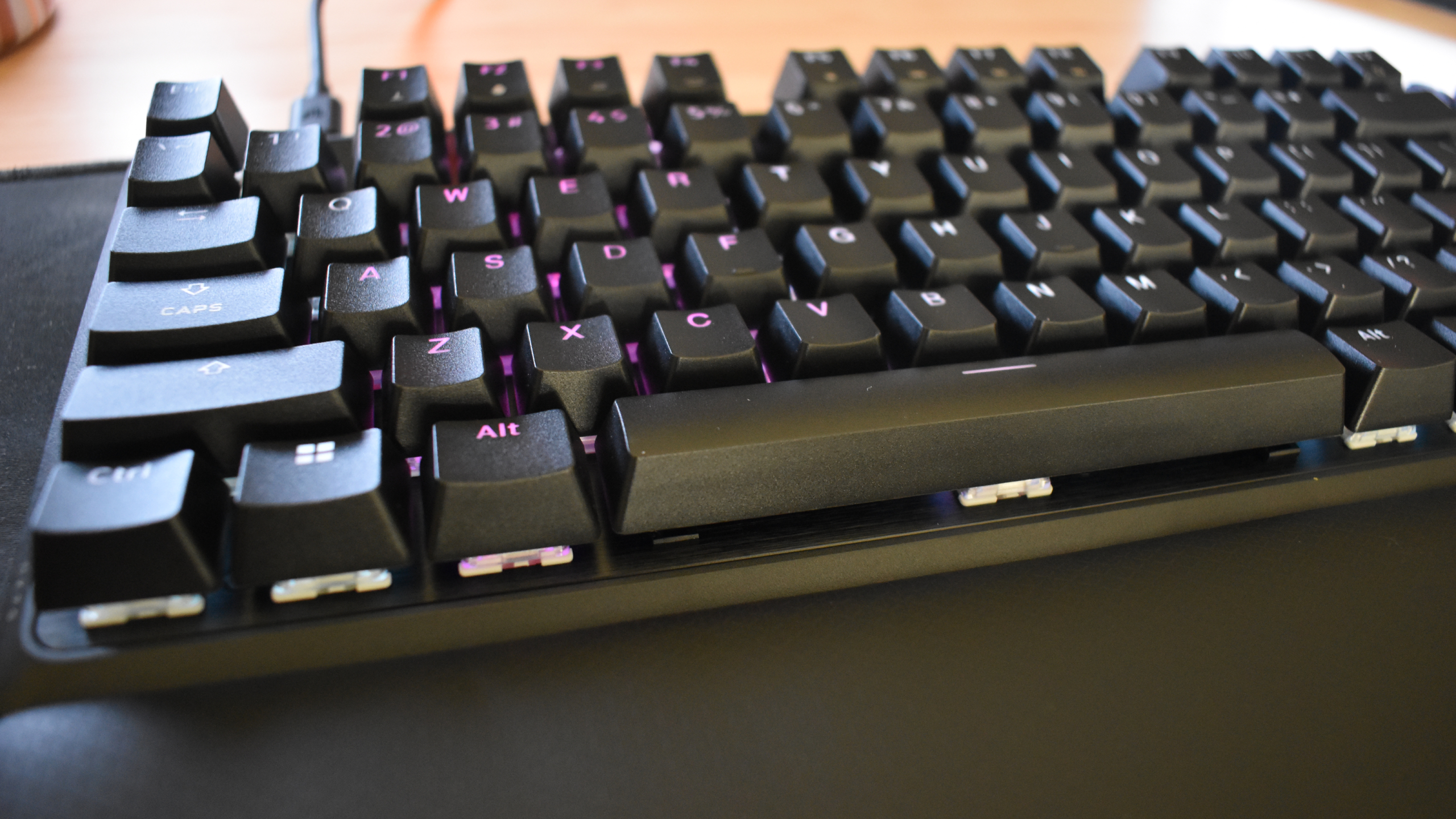 Corsair K70 Pro TKL gaming keyboard on black mouse pad, RGB powered