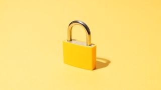A yellow padlock standing centrally in front of a flat pale yellow background