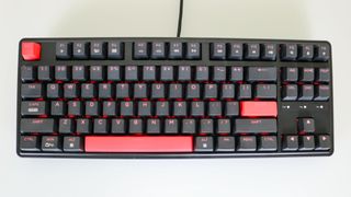 The Keychron C3 Pro on a desk with its red LED backlighting enabled
