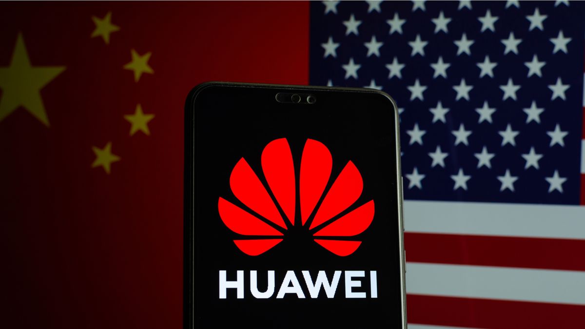 Huawei logo on a smartphone and flags of China and US on the blurred background