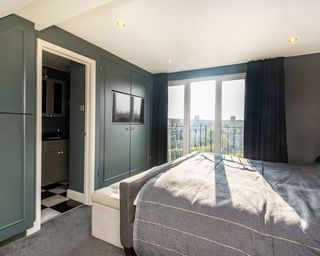 dark green bedroom with grey bed and attached bathroom