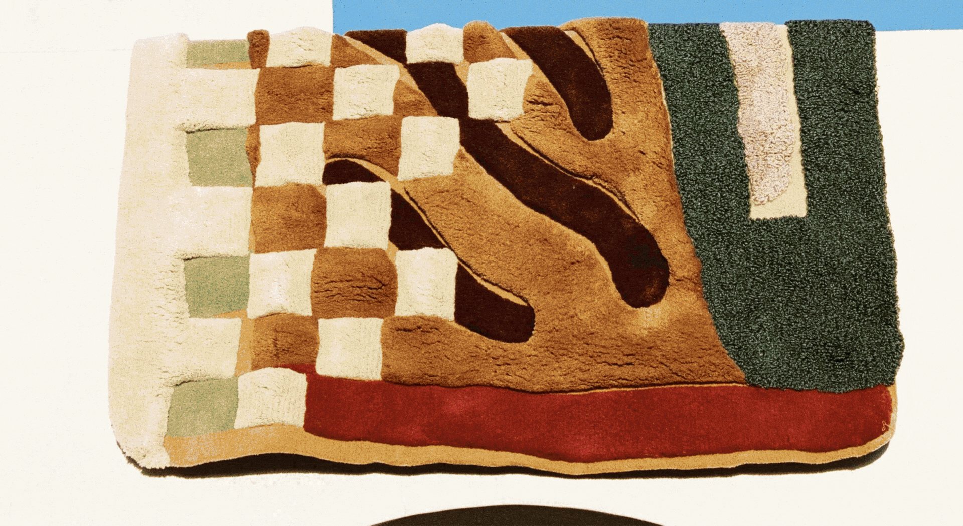 A rotating gif showcasing colorful rugs, ceramics, and framed illustrations made with textiles, all presented in a warm, summery setting.