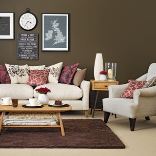 Brown painted living room with cream sofa and armchair and cream carpet