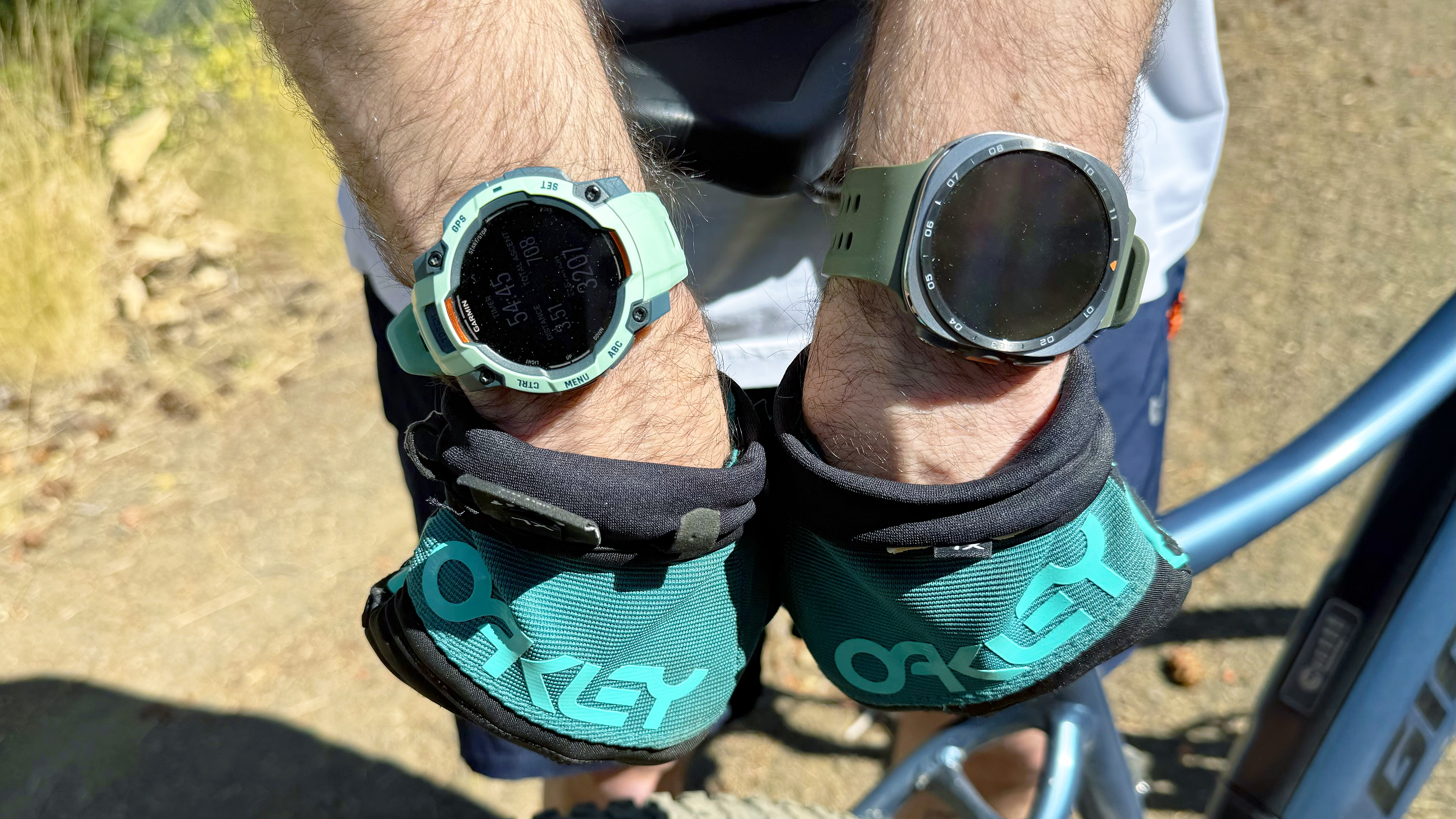 Close-up of the Samsung Galaxy Watch Ultra 2 and Garmin Instinct 3 in the mountains during an e-biking excursion