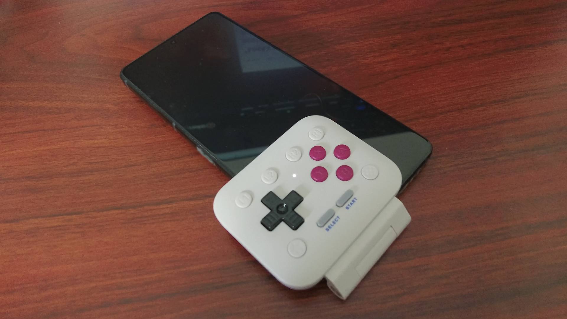 8Bitdo FlipPad connected into Asus ROG Phone with controller sticking out to the left due to USB-C port placement.