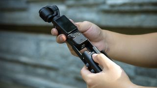 Somine holding the DJI Osmo Pocket 3 with SmallRig cage attached