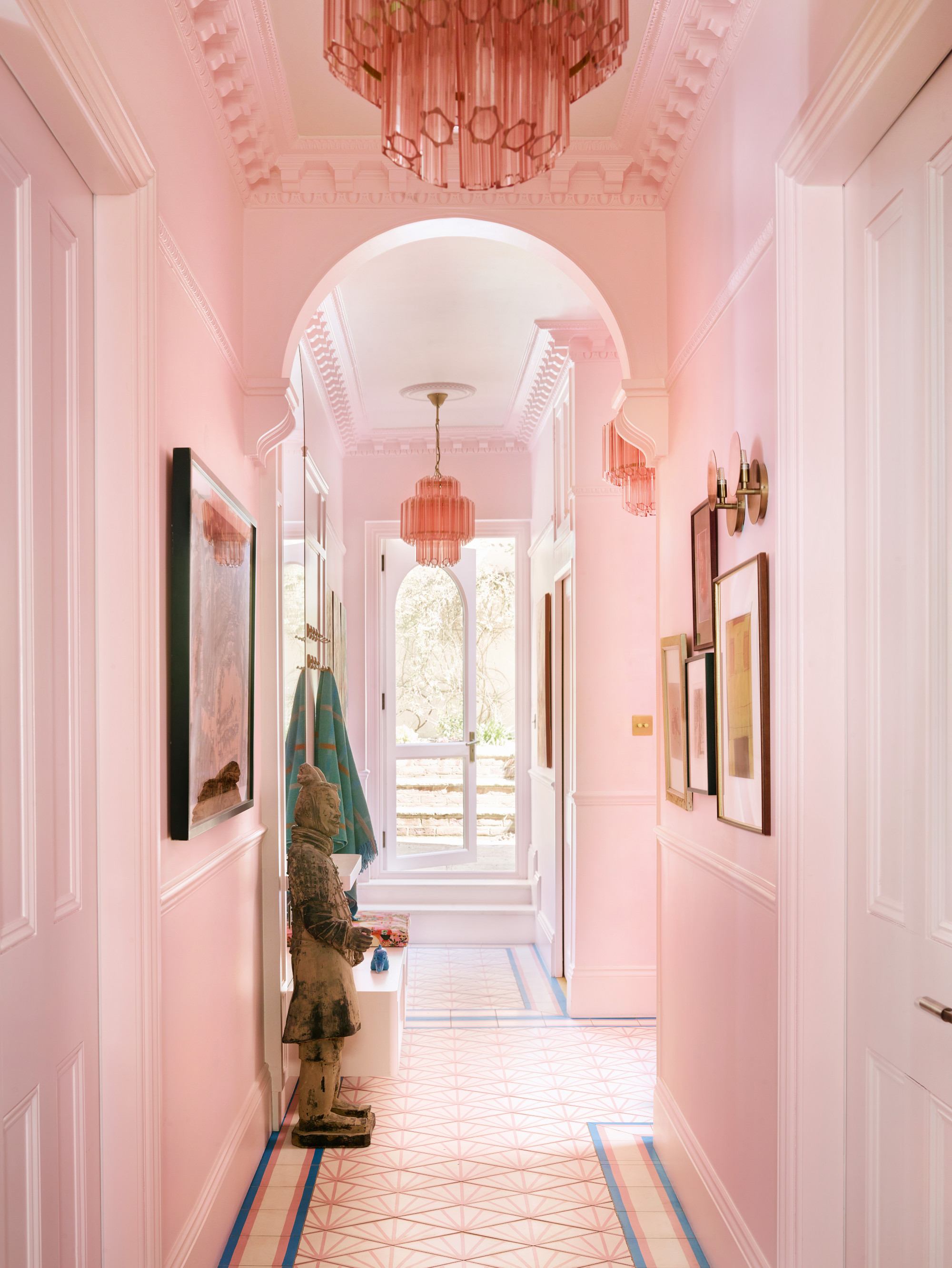 Pale pink hallway with blue, pink and white patterned tiled floor