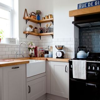 white kitchen with wooden counter tops and black stove