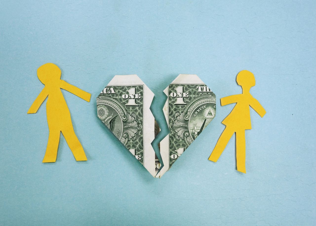 Paper couple and broken dollar heart - divorce or money trouble concept