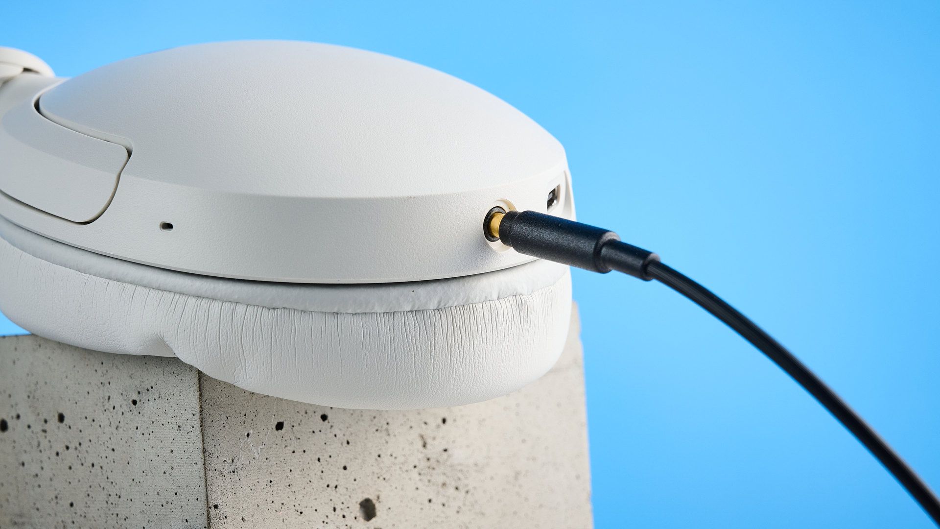 Sony WH-CH730N in white photographed in front of a blue background