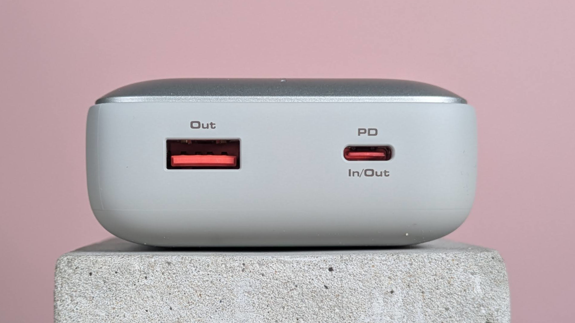 Close-up of ports on Aukey Spark Mini 20000, on plinth with pink background