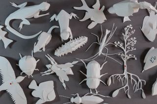 Paper models of creatures on dark table