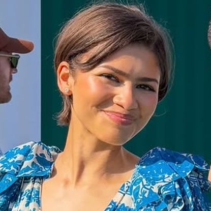 Zendaya posed with a fan at tom holland's tennis event in a blue sundress, The Row Mary Janes, and a butter yellow Louis Vuitton bag