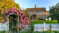 White fence in large backyard of colonial-style home