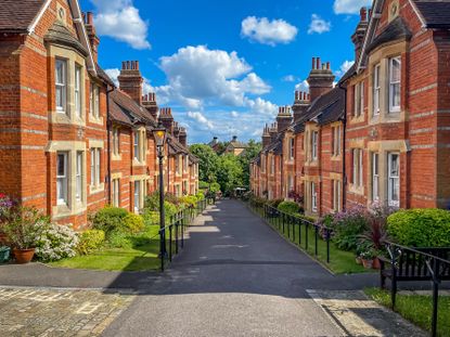 Beautiful Sunny Street View in residential district with row of old expensive houses and apartments in London, UK