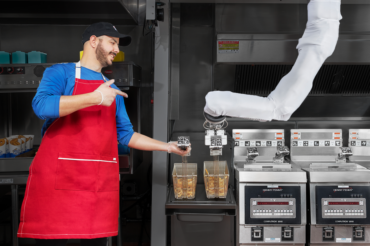 Man in commercial kitchen deep frying french fries