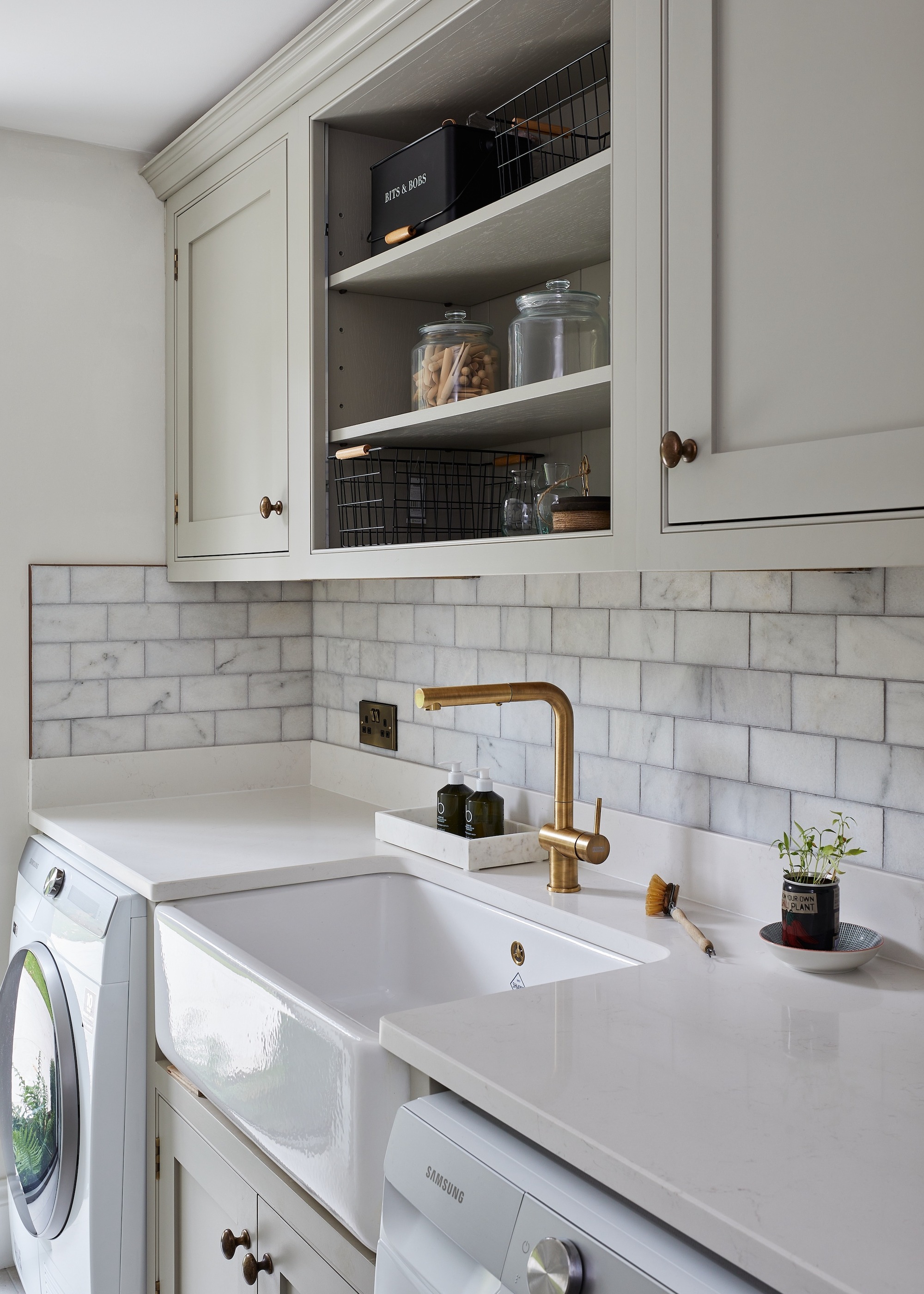 grey kitchen with washing machine and dryer either side of the sink