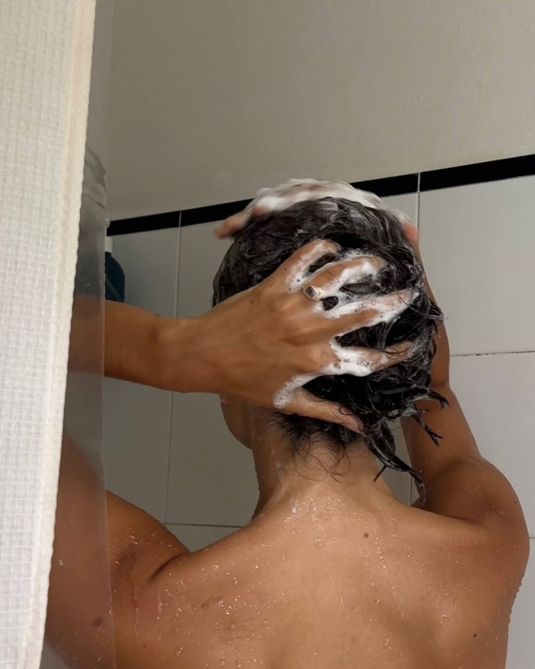 An image of influencer @bellathomas using shampoo for oily hair.