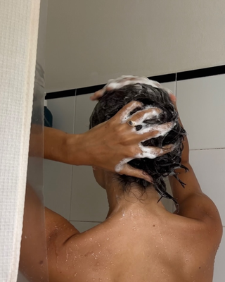 An image of influencer @bellathomas using shampoo for oily hair.