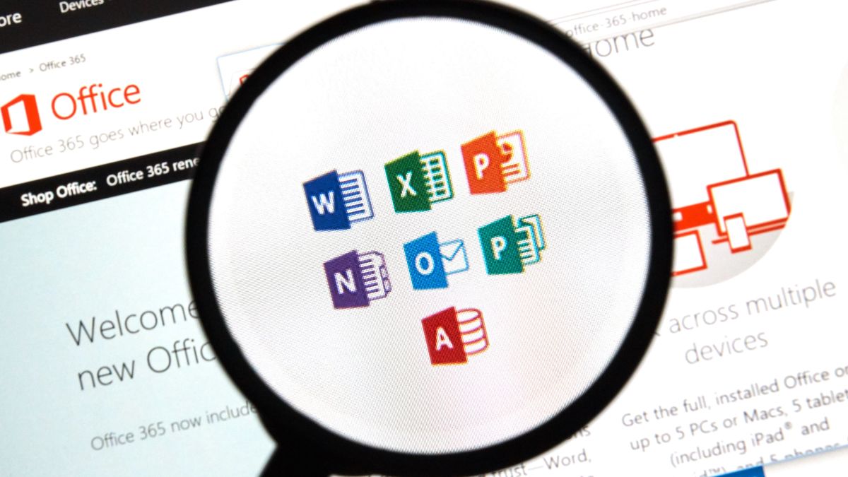 A magnifying glass hovering over a PC screen with the symbols for Microsoft Office software displayed