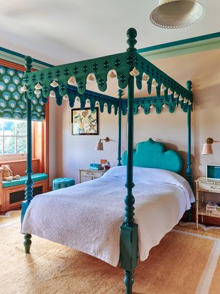 A bedroom with a green four poster bed