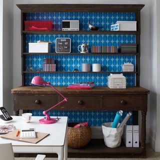 room with blue patterned dresser and pink lamp
