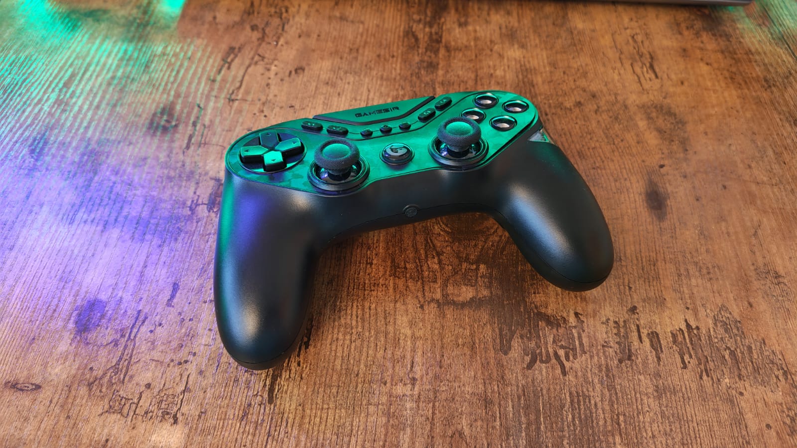 A black GameSir Tarantula Pro lying on a desk under green lighting