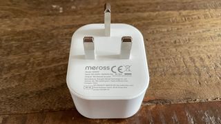 The bakc of the Meross Smart Wi-Fi Plug Mini MSS110 on a wooden table