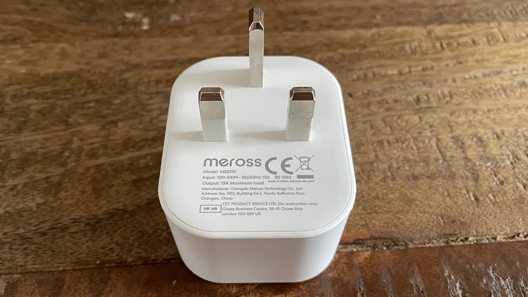 Bakc dari Meross Smart Wi-Fi Plug Mini MSS110 di atas meja kayu